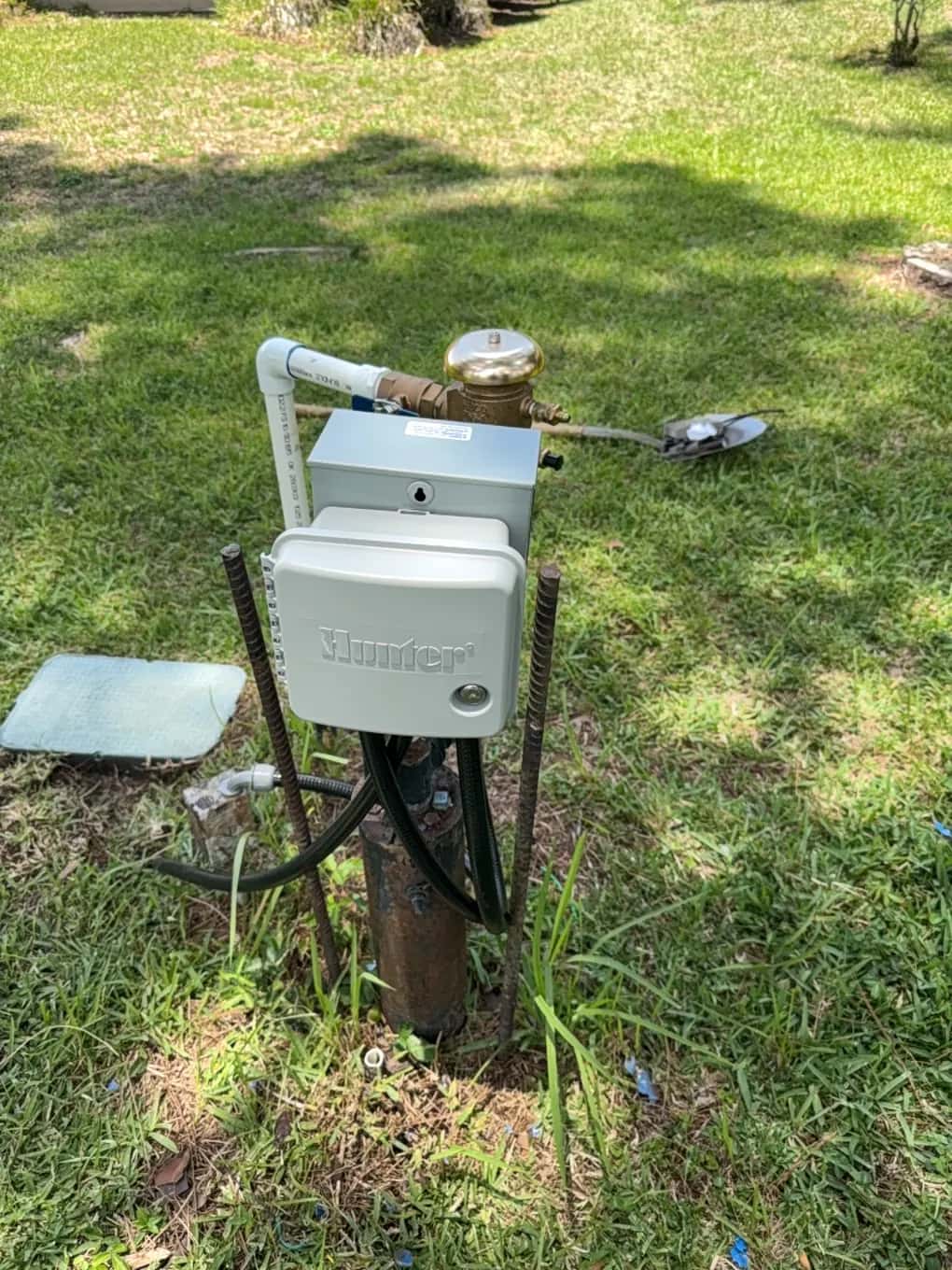 Hunter irrigation controller and pump control box mounted at an irrigation well with a backflow preventer