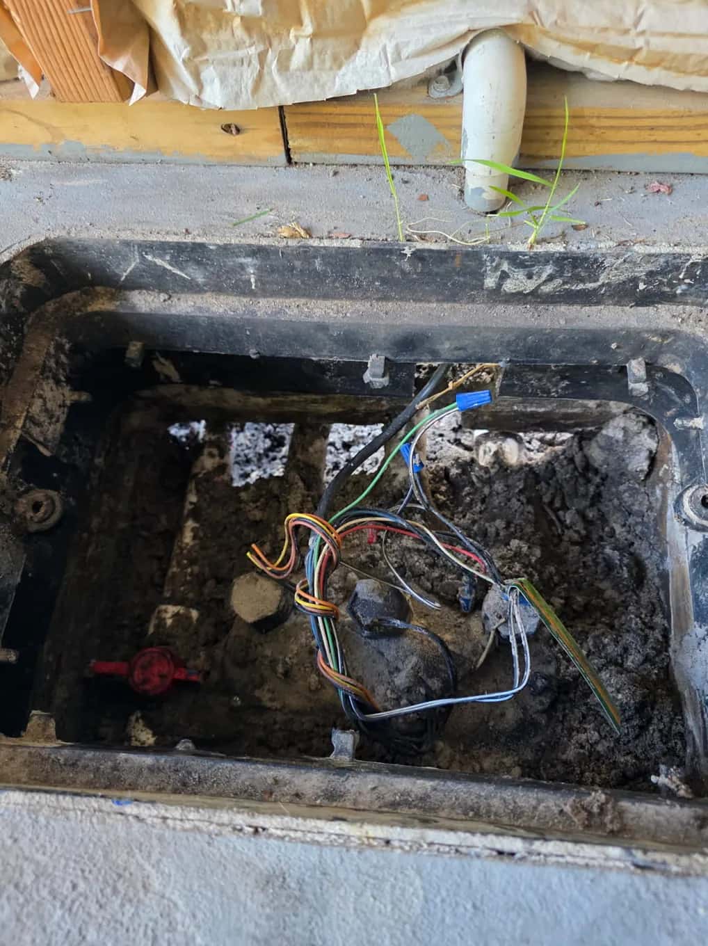 Open irrigation valve box with zone valve wiring exposed for troubleshooting