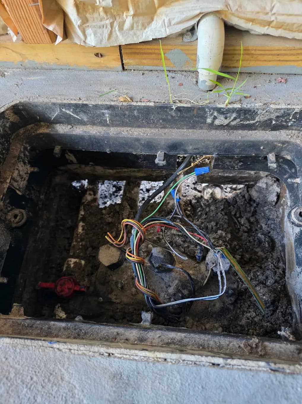 Open irrigation valve box with zone valve wiring exposed for troubleshooting