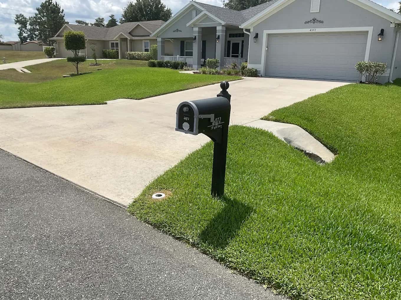 Manicured front lawn and driveway kept green by an irrigation system
