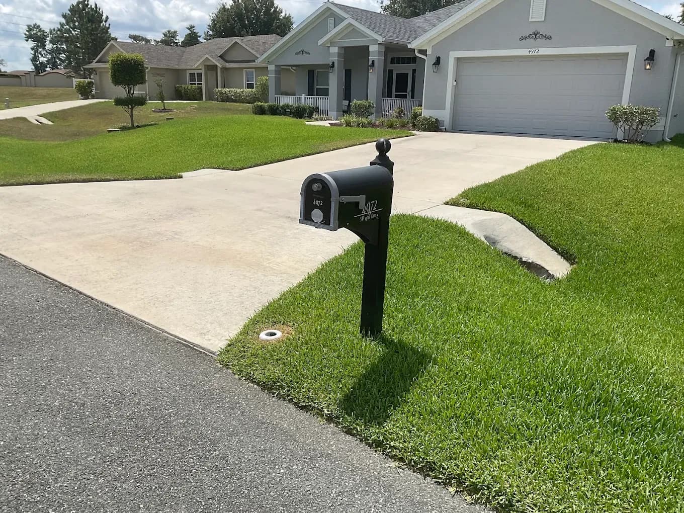 Manicured front lawn and driveway kept green by an irrigation system
