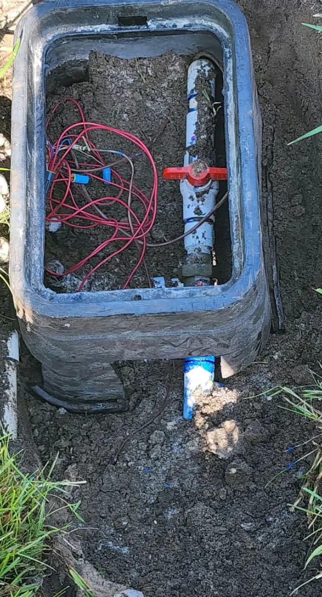 New irrigation valve box set in the ground around a zone valve and its wiring