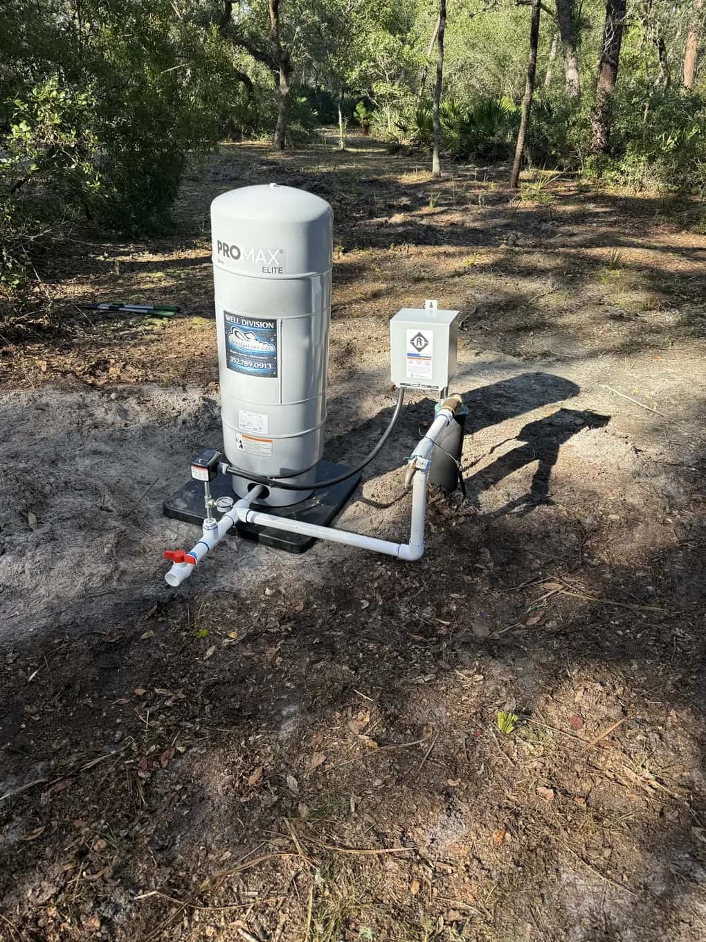 New well pressure tank with an IrriGators Well Division label, plumbed in on a pad outdoors