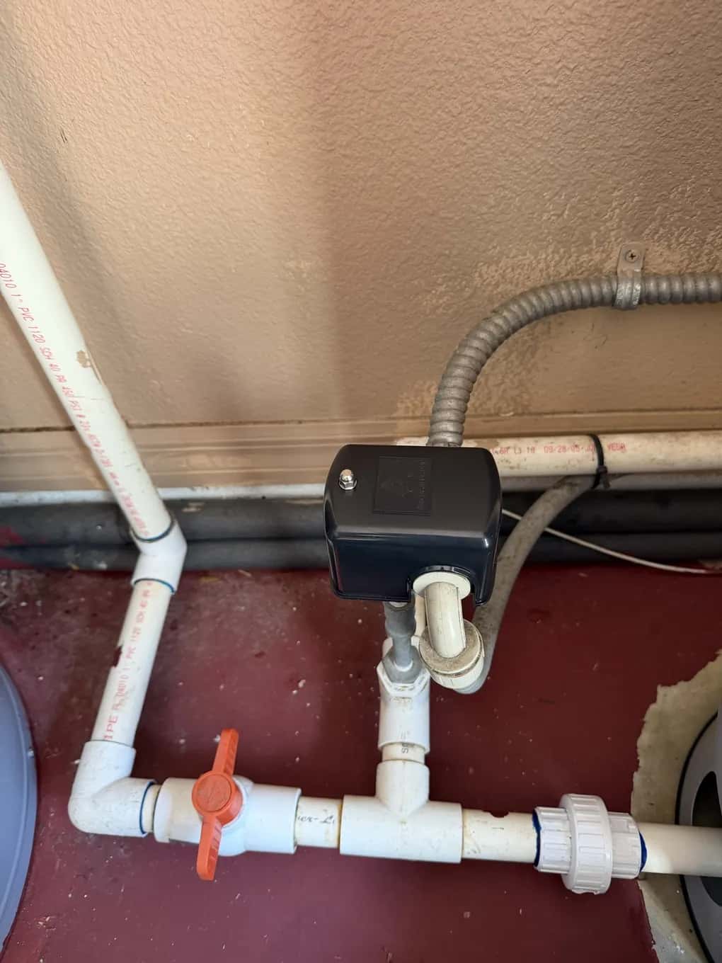 New well pump pressure switch installed on PVC plumbing with a red shut-off valve