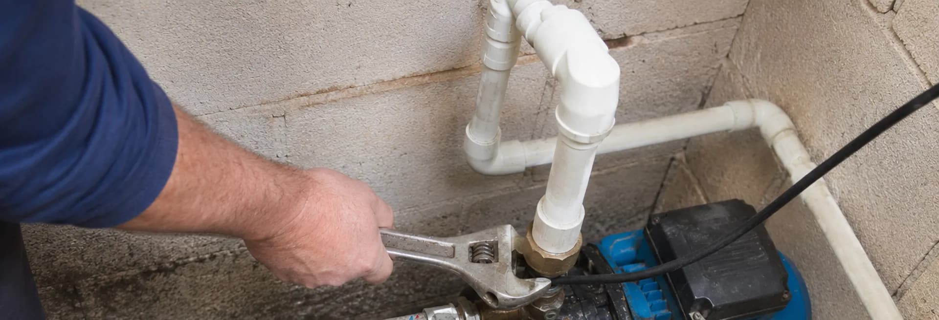 Technician servicing a well pump in a pump house